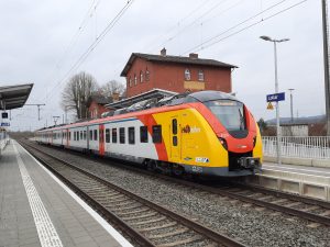 Der Bahnhof in Lollar mit dem historischen Gebäude in Insellage mit dem "Kulturbahnhof". Es hält ein Zug der RB41 an Gleis 1 bei der Fahrt von Kirchhain nach Frankfurt Hbf.